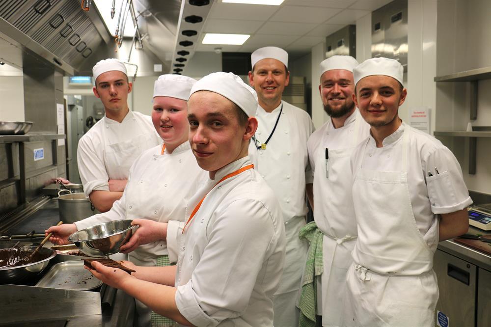 Lewis and Craig (first and second right) and Rees (far left) pass on their skills to current students Eleanor Kiff, 17, and Tim Foster, 18, watched by chef tutor Mark Jones.