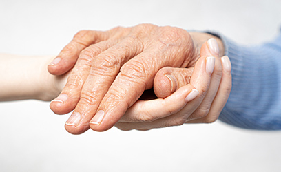 Close up of two people holding hands in a caring way