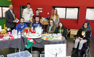 Image of a group of students behind a small stall selling Christmas items.