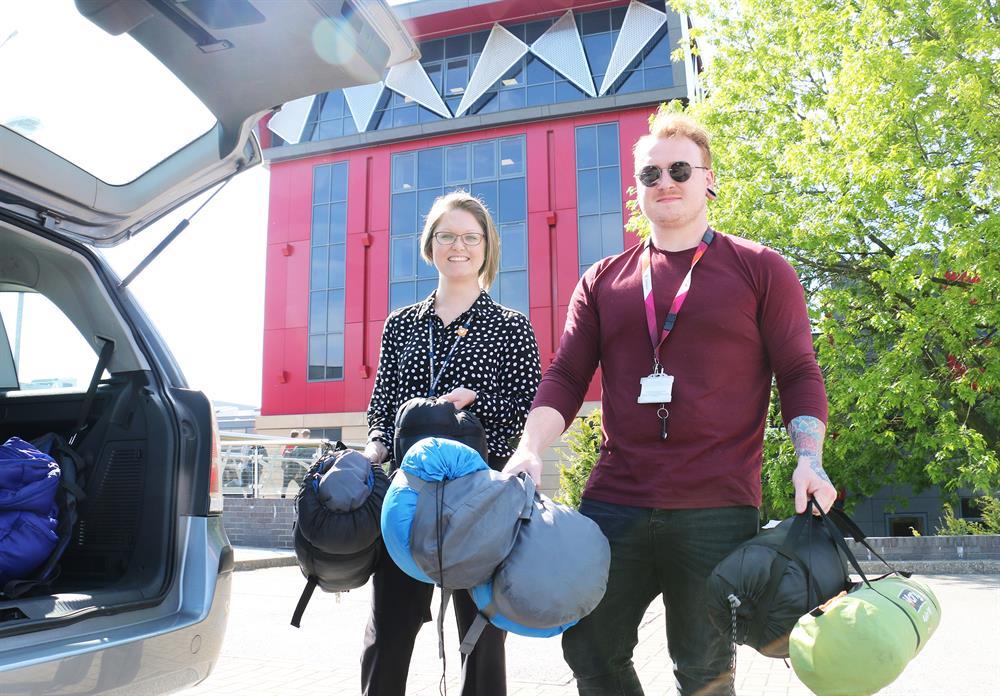 Sam Cooling-Severns (left) helps Louis Hope (right) load up the outreach vehicle with supplies